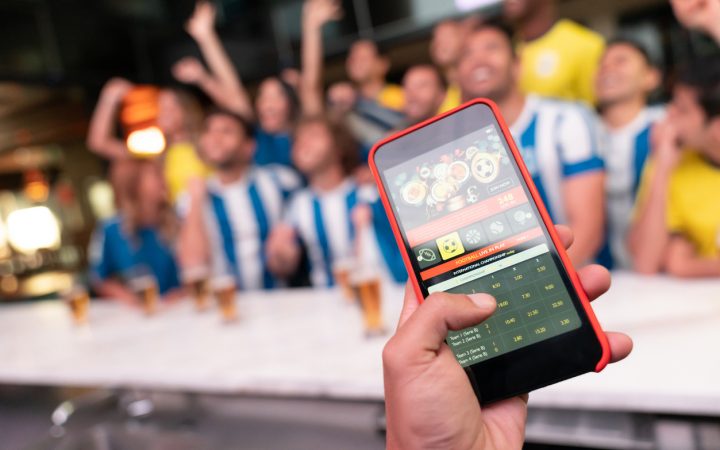 一男子拿着手机在网上赌足球比赛中获胜的特写镜头。屏幕中的**设计是由我们从零开始**