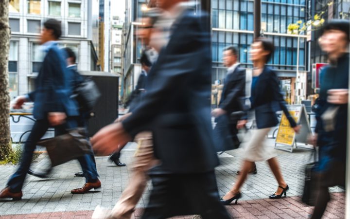 一群模糊的商务人士在日本的街道上通勤