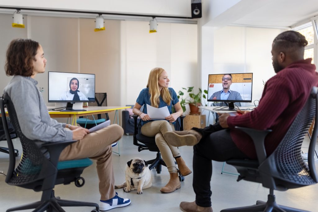 创业公司的商人们在一个小办公室开会，同事们通过视频电话参加会议。不同的创业团队通过远程视频会议与同事会面。